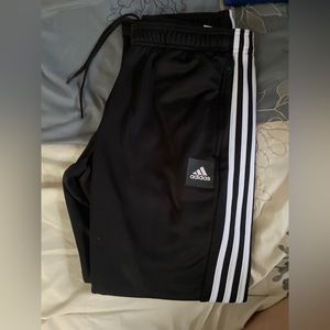 Black Adidas sweatpants with zippers on the side leg